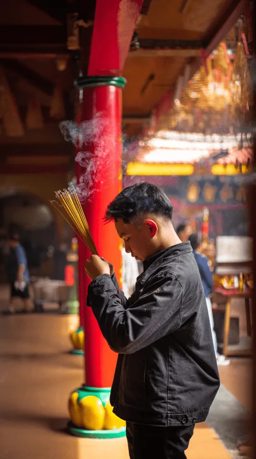 Ako si užiť návštevu Ho Chi Minh City vo Vietname 9 Modliaci sa mladý chlapec v budhistickom chráme v čínskej štvrti.